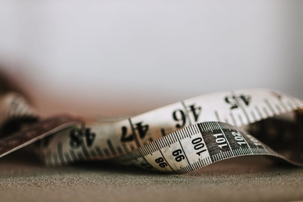 Artistic shallow focus image of a measuring tape showing numbers and units.