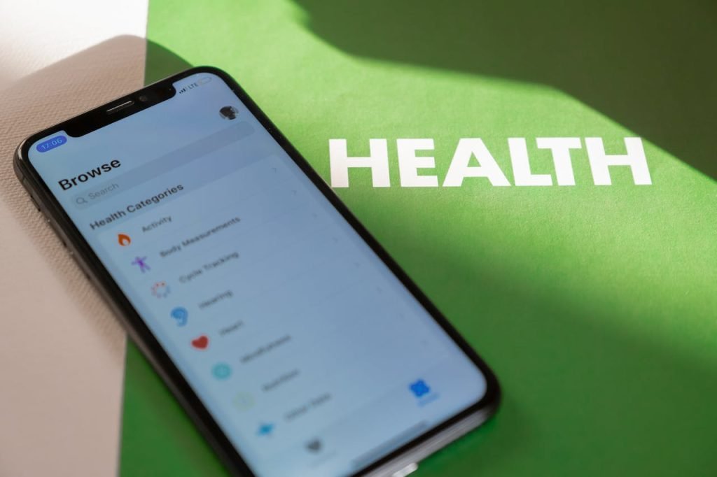 Close-up of a smartphone displaying a health app on a green surface with HEALTH text.